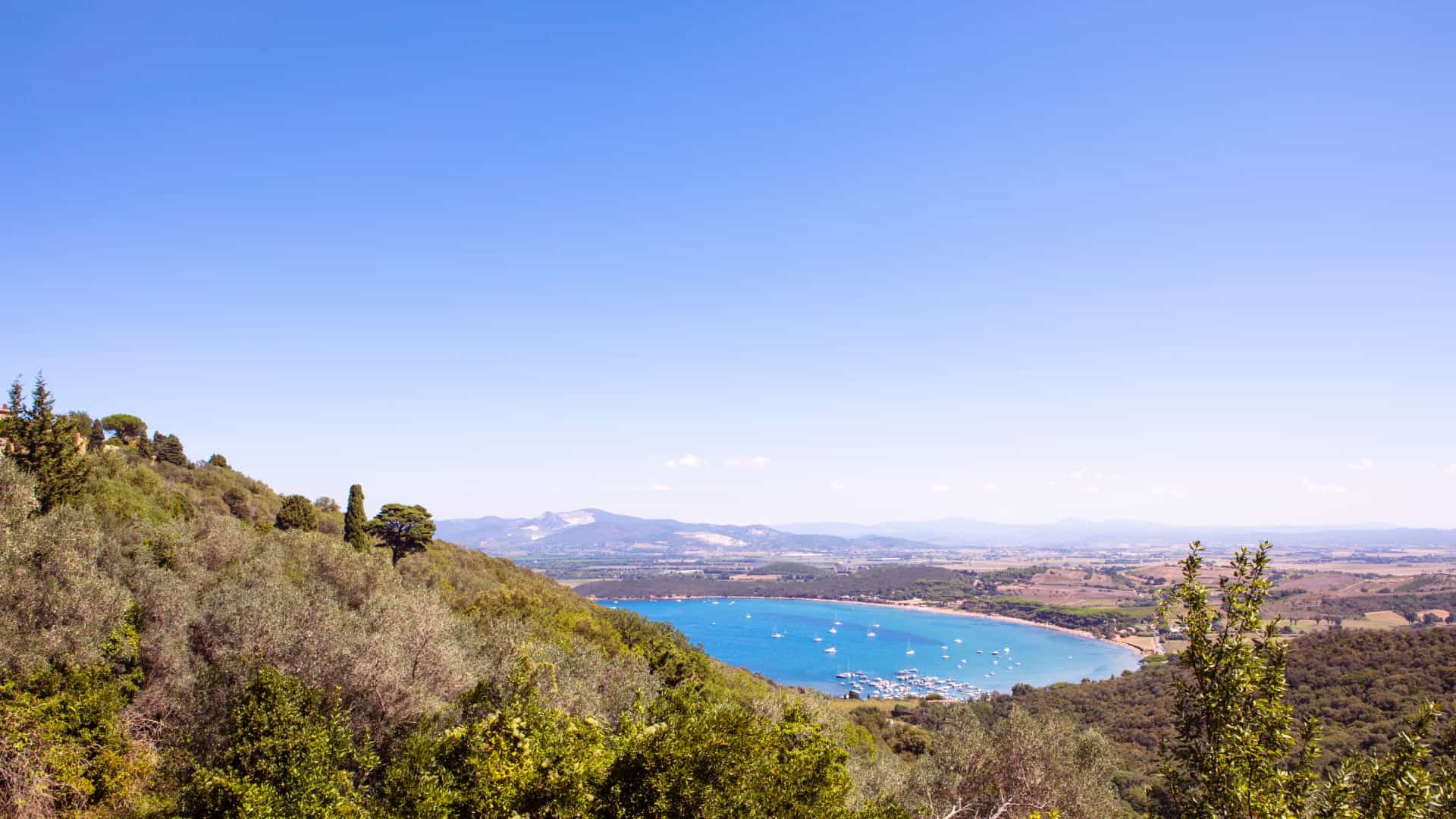 Entfernter Panoramablick auf den Strand von Baratti im Golf von Baratti in der Toskana