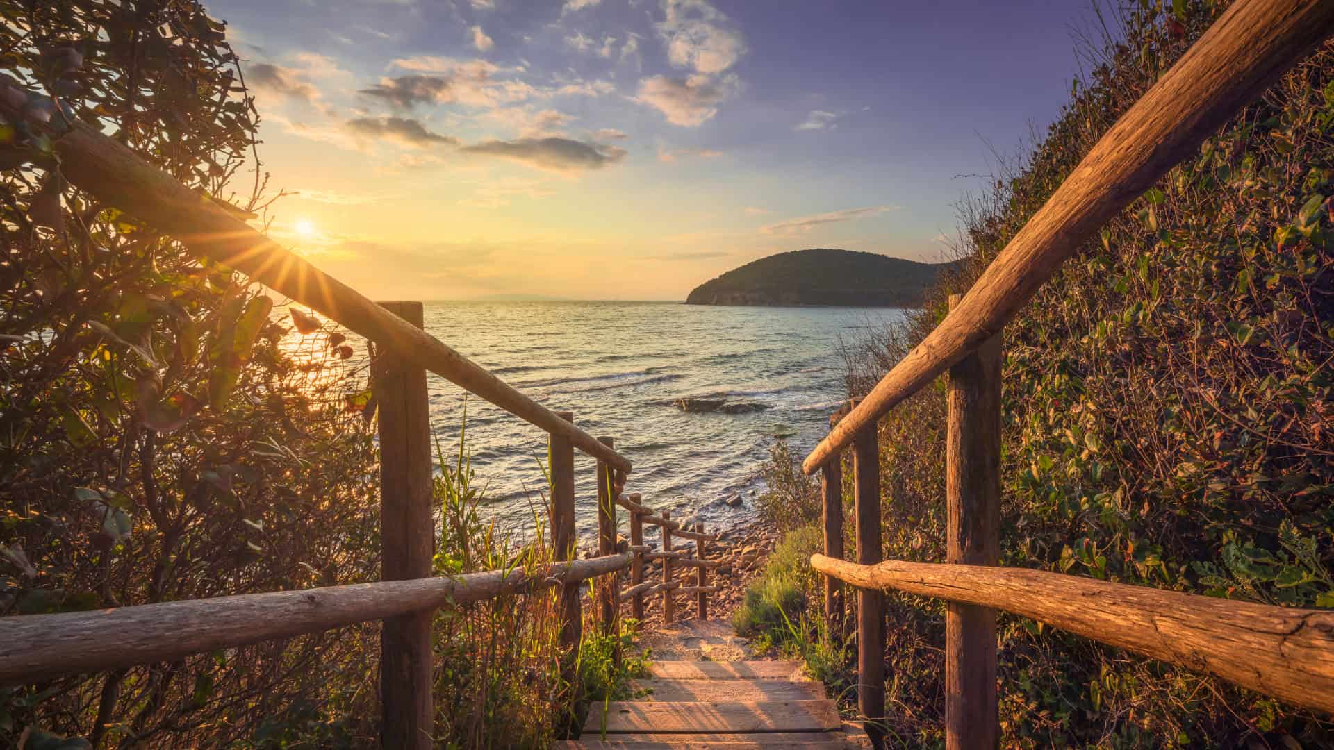 Holzsteg, der zum Strand Cala Violina führt